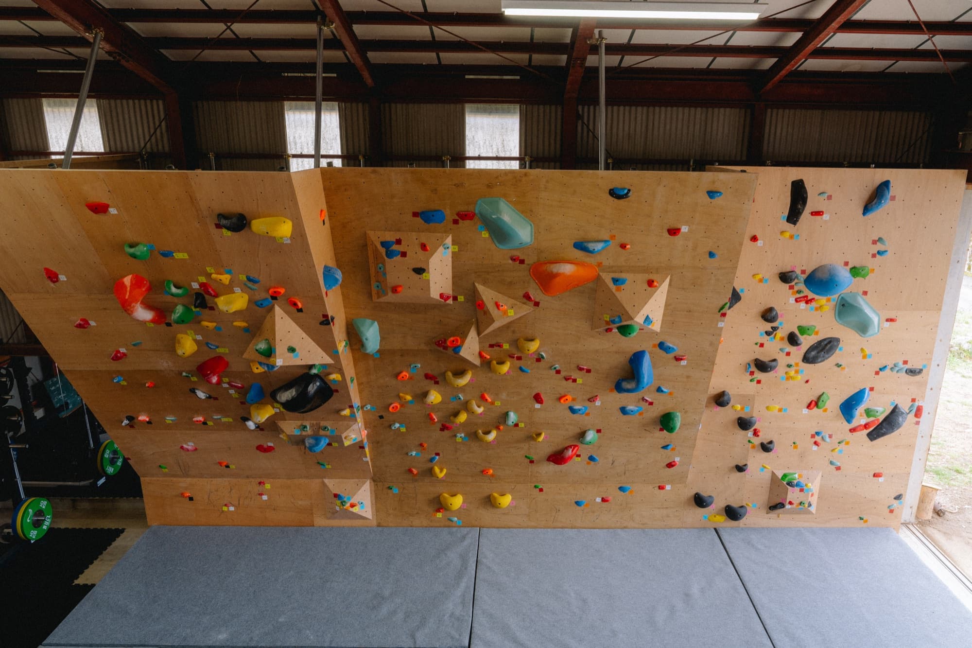Bouldering wall with colorful holds at multiple angles